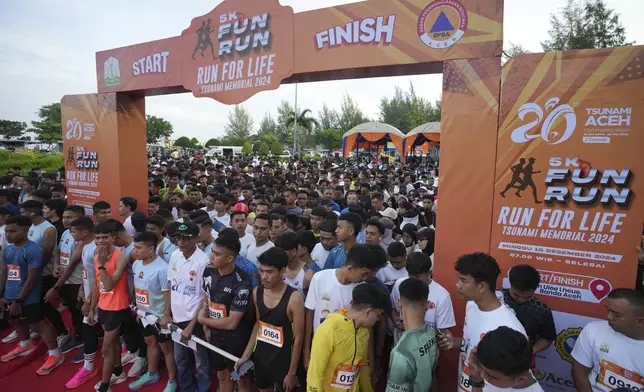 Participants prepare for the start of a 5km running event titled "Run for Life, Tsunami Memorial 2024" held to commemorate the 20th anniversary of the Indian Ocean tsunami, in Banda Aceh, Aceh province, Indonesia, Sunday, Dec. 15, 2024. (AP Photo/Achmad Ibrahim)