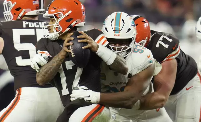 Cleveland Browns quarterback Dorian Thompson-Robinson (17) is pressured by Miami Dolphins defensive tackle Calais Campbell (93) during the second half of an NFL football game Sunday, Dec. 29, 2024, in Cleveland. (AP Photo/Sue Ogrocki)