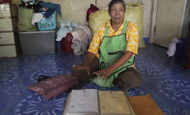 A survivor from tsunami Somnuek Chuaykerd talks to the Associated Press reporters during an interview show emergency bag with important document at Ban Nam Khem, Takuapa district of Phang Nga province, southern Thailand, Monday, Dec. 9, 2024. (AP Photo/Sakchai Lalit)