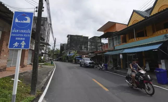 A motorcycle rides past a tsunami evacuation route sign Ban Nam khem, Takuapa district of Phang Nga province, southern Thailand, Monday, Dec. 9, 2024. (AP Photo/Sakchai Lalit)