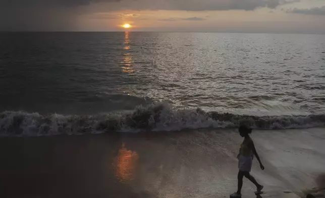 A woman walks on Bang Niang Beach, where tsunami hit 2004, Takuapa district of Phang Nga province, southern Thailand, Sunday, Dec. 8, 2024. (AP Photo/Sakchai Lalit)