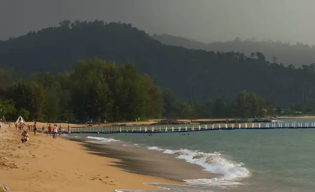 Tourists play on Bang Niang Beach, where tsunami hit 2004, Takuapa district of Phang Nga province, southern Thailand, Sunday, Dec. 8, 2024. (AP Photo/Sakchai Lalit)