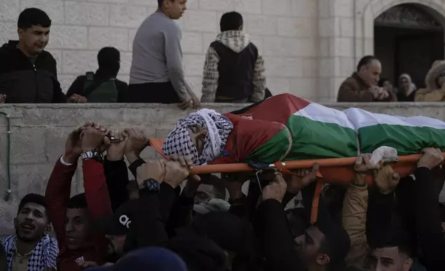 Palestinian mourners carry the body of Mohammed Abu Kishk, who was killed in clashes with Israeli forces during his funeral at the Askar refugee camp in the Israeli-occupied West Bank, Dec. 17, 2024 (AP Photo/Majdi Mohammed).