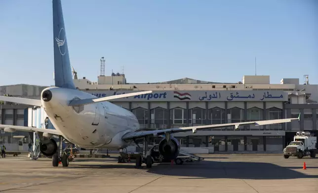 A Syrian Air airplane is seen parked at the terminal as the airport reopens for internal flights in Damascus, Syria, Wednesday, Dec. 18, 2024. (AP Photo/Omar Sanadiki)