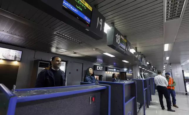 Employees stand at check-in counters as the airport reopens for domestic flights in Damascus, Syria, Wednesday, Dec. 18, 2024. (AP Photo/Omar Sanadiki)