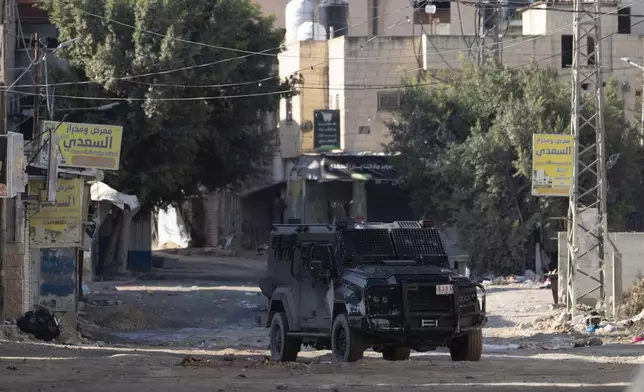 Armored Palestinian security vehicles are seen on the road as Palestinian forces mount a major raid against militants in the Jenin refugee camp in the Israeli-occupied West Bank, Monday, Dec. 23, 2024. (AP Photo/Majdi Mohammed)