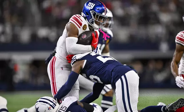 New York Giants wide receiver Malik Nabers (1) is tackled by Dallas Cowboys cornerback DaRon Bland (26) during the first half of an NFL football game in Arlington, Texas, Thursday, Nov. 28, 2024. (AP Photo/Jerome Miron)