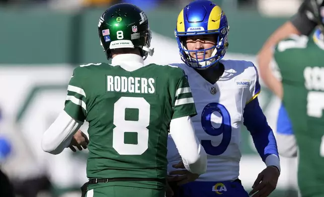 New York Jets quarterback Aaron Rodgers (8) greets Los Angeles Rams quarterback Matthew Stafford (9) before an NFL football game in East Rutherford, N.J., Sunday, Dec. 22, 2024. (AP Photo/Seth Wenig)