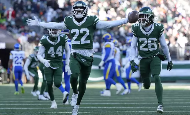 New York Jets safety Tony Adams (22) celebrates with cornerback Brandin Echols (26) after intercepting a pass during the first half of an NFL football game against the Los Angeles Rams in East Rutherford, N.J., Sunday, Dec. 22, 2024. (AP Photo/Julia Demaree Nikhinson)