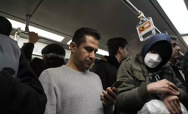 A man uses his smartphone while riding the subway in Tehran, Iran, Tuesday, Dec. 24, 2024. (AP Photo/Vahid Salemi)