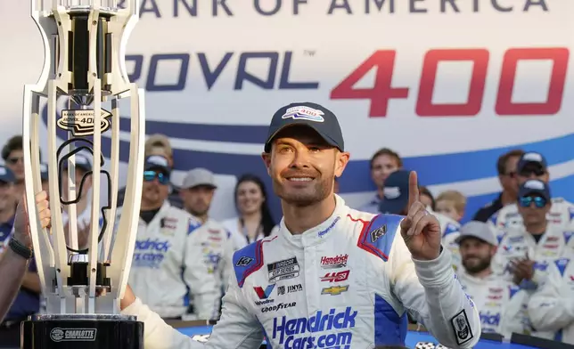 FILE - Kyle Larson poses with the trophy with his daughter Audrey, 6, after winning a NASCAR Cup Series auto race at Charlotte Motor Speedway in Concord, N.C., Oct. 13, 2024. (AP Photo/Chuck Burton, File)