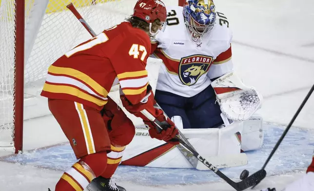 Florida Panthers goalie Spencer Knight, right, blocks the net on Calgary Flames' Connor Zary during the third period of an NHL hockey game in Calgary, Alberta, Saturday, Dec. 14, 2024. (Jeff McIntosh/The Canadian Press via AP)