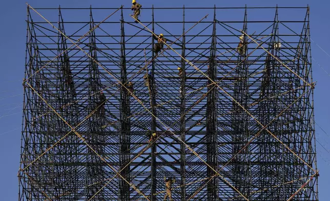 Workers prepare scaffolding ahead of a new year countdown event to be held in Beijing, Friday, Dec. 27, 2024. (AP Photo/Ng Han Guan)