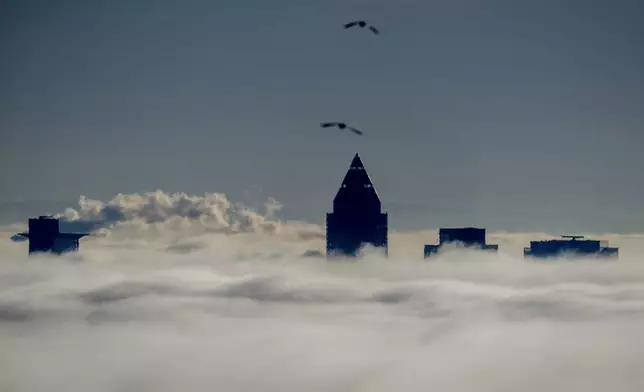 The buildings of the banking district come out of the thick fog over Frankfurt, Germany, Friday, Dec. 27, 2024. (AP Photo/Michael Probst)