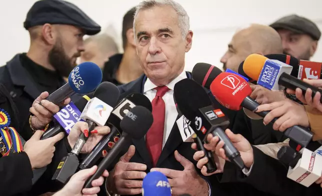 Calin Georgescu, an independent candidate for president who came first after the first round of presidential elections, speaks to media after casting his vote in the country's parliamentary elections, in Mogosoaia, Romania, Sunday, Dec. 1, 2024. (AP Photo/Vadim Ghirda)