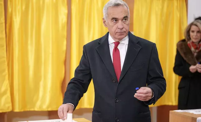 Calin Georgescu, an independent candidate for president who came first after the first round of presidential elections, casts his vote in the country's parliamentary election in Mogosoaia, Romania, Sunday, Dec. 1, 2024. (AP Photo/Andreea Alexandru)