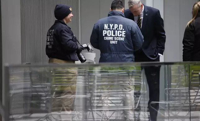 Members of the New York police crime scene unit investigate the scene outside the Hilton Hotel in midtown Manhattan where Brian Thompson, the CEO of UnitedHealthcare, was fatally shot Wednesday, Wednesday, Dec. 4, 2024, in New York. (AP Photo/Stefan Jeremiah)