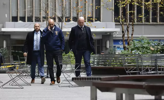 New York police homicide investigators walk outside the Hilton Hotel in midtown Manhattan where Brian Thompson, the CEO of UnitedHealthcare, was fatally shot Wednesday, Wednesday, Dec. 4, 2024, in New York. (AP Photo/Stefan Jeremiah)