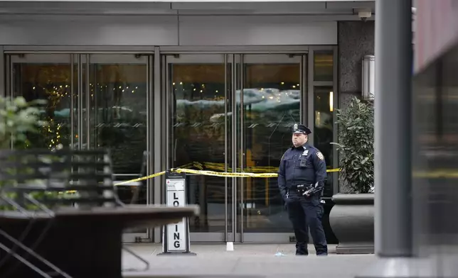 A New York police officer stands outside the Hilton Hotel in midtown Manhattan where Brian Thompson, the CEO of UnitedHealthcare, was fatally shot, Wednesday, Dec. 4, 2024, in New York. (AP Photo/Stefan Jeremiah)