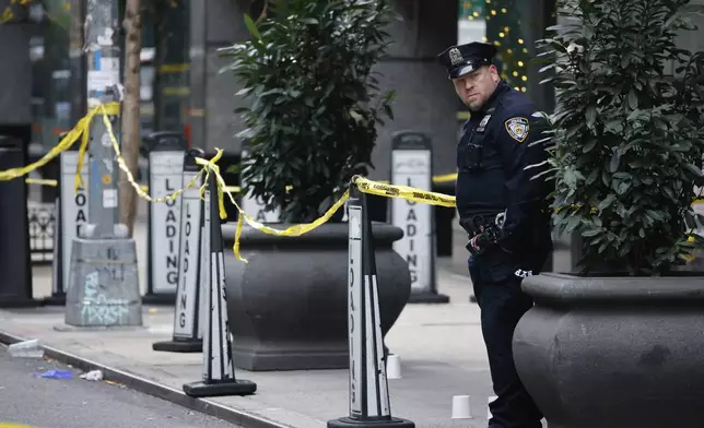 A New York police officer stands outside the Hilton Hotel in midtown Manhattan where Brian Thompson, the CEO of UnitedHealthcare, was fatally shot, Wednesday, Dec. 4, 2024, in New York. (AP Photo/Stefan Jeremiah)