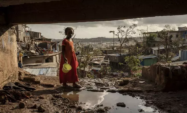 A girl walks in the Kaweni slum on the outskirts of Mamoudzou, in the French Indian Ocean island of Mayotte, Dec. 19, 2024, in the aftermath of Cyclone Chido. (AP Photo/Adrienne Surprenant)