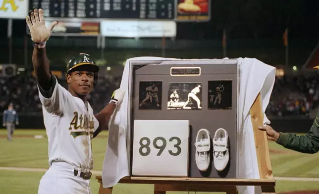 FILE - Rickey Henderson waves to the crowd during a presentation after he stole third base against the Toronto Blue Jays in the seventh inning to break Ty Cobb's career stolen base record, at Oakland Coliseum in Oakland, Calif., May 30, 1990. (AP Photo/Paul Sakuma, File)