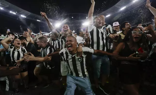 Botafogo soccer fans celebrate their team's third goal scored by Junior Santos against Atletico Mineiro in the Copa Libertadores title match in Argentina, broadcast on a giant screen at a watch party at the Nilton Santos Stadium, in Rio de Janeiro, Saturday, Nov. 30, 2024. (AP Photo/Bruna Prado)