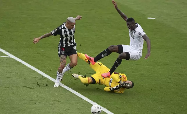 Luiz Henrique of Brazil's Botafogo, right. is fouled by goalkeeper Everson of Brazil's Atletico Mineiro inside the penalty area during a Copa Libertadores final soccer match at Monumental stadium in Buenos Aires, Argentina, Saturday, Nov. 30, 2024. (AP Photo/Natacha Pisarenko)