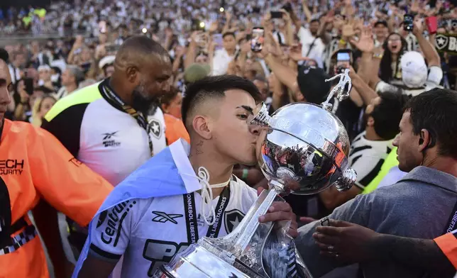 Thiago Almada of Brazil's Botafogo kisses the trophy as he celebrates with teammates after winning the Copa Libertadores final soccer match against Brazil's Atletico Mineiro at Monumental stadium in Buenos Aires, Argentina, Saturday, Nov. 30, 2024. (AP Photo/Ignacio Amiconi)