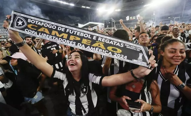 Botafogo soccer fans celebrate winning the Copa Libertadores title match in Argentina, against Brazil's Atletico Mineiro, during a watch party at the Nilton Santos Stadium, in Rio de Janeiro, Saturday, Nov. 30, 2024. (AP Photo/Bruna Prado)