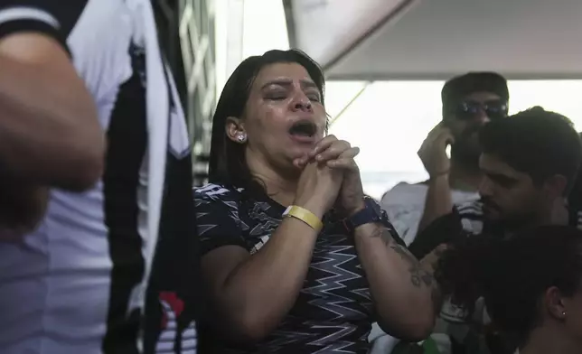 A Brazil's Atletico Mineiro soccer fan reacts as she watches a live broadcast of her team go up against Brazil's Botafogo in the Copa Libertadores title match, at a bar in Belo Horizonte, Brazil, Saturday, Nov. 30, 2024. (AP Photo/Thomas Santos)