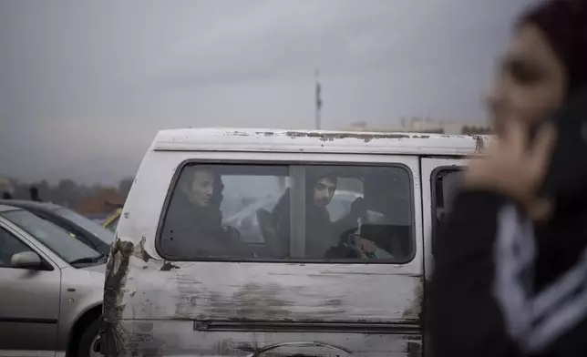 Commuters ride on a transportation van in Damascus, Syria, Sunday, Dec. 29, 2024. (AP Photo/Leo Correa)