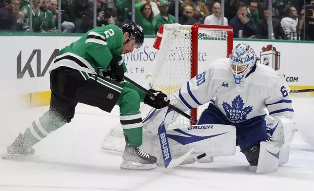 Dallas Stars defenseman Brendan Smith (2) has a shot defended by Toronto Maple Leafs goaltender Joseph Woll (60) during the first period of an NHL hockey game in Dallas, Wednesday, Dec. 18, 2024. (AP Photo/Michael Ainsworth)