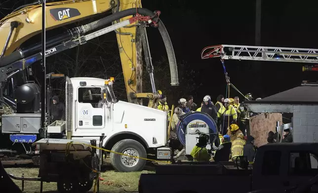 Rescue workers search in a sinkhole for Elizabeth Pollard, who disappeared while looking for her cat, in Marguerite, Pa., Tuesday, Dec. 3, 2024. (AP Photo/Gene J. Puskar)