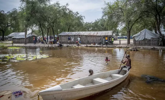 Children ride in a small canoe around the area where they live in Jonglei state, South Sudan, Thursday, Nov. 14, 2024. (AP Photo/Florence Miettaux)