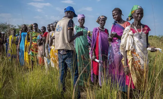 South Sudanese women line up for food rations at a World Food Programme (WFP) distribution point organized by Catholic Relief Services in Jonglei state, South Sudan, Wednesday, Nov. 13, 2024. (AP Photo/Florence Miettaux)