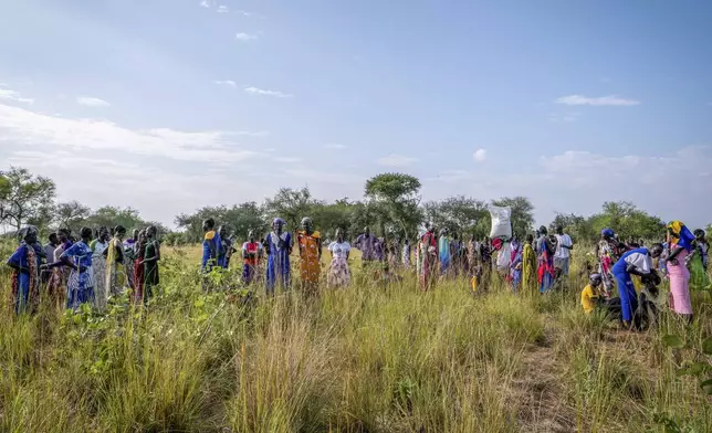 People wait for food rations at a World Food Programme (WFP) distribution point organized by Catholic Relief Services in Jonglei state, South Sudan, Wednesday, Nov. 13, 2024. (AP Photo/Florence Miettaux)