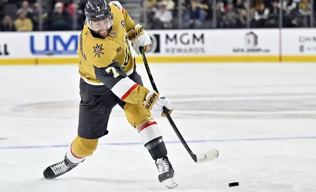 Vegas Golden Knights defenseman Alex Pietrangelo (7) takes a shot against the Vancouver Canucks during the second period of an NHL hockey game Thursday, Dec. 19, 2024, in Las Vegas. (AP Photo/David Becker)