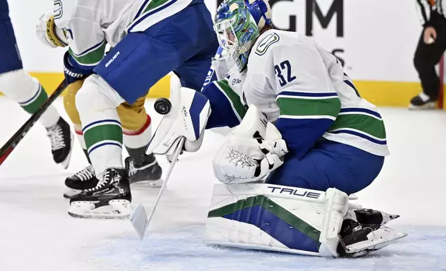 Vancouver Canucks goaltender Kevin Lankinen (32) defends the net against the Vegas Golden Knights during the second period of an NHL hockey game Thursday, Dec. 19, 2024, in Las Vegas. (AP Photo/David Becker)