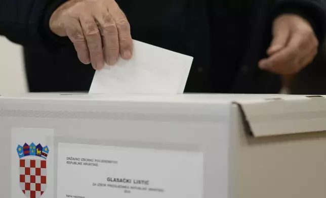 A man casts his ballot during a presidential election at a polling station in Zagreb, Croatia, Sunday, Dec. 29, 2024. (AP Photo/Darko Bandic)