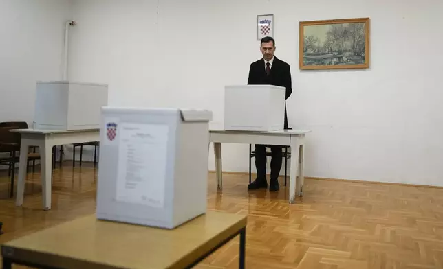 Dragan Primorac, the candidate of the ruling Croatian Democratic Union (HDZ) prepares his ballot during a presidential election at a polling station in Zagreb, Croatia, Sunday, Dec. 29, 2024. (AP Photo/Darko Bandic)