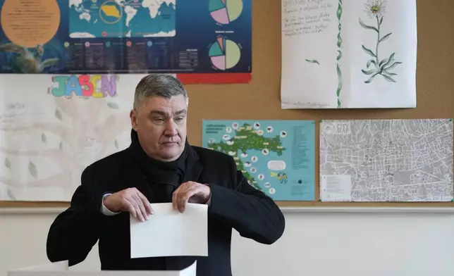 Croatia's President Zoran Milanovic prepares his ballot during a presidential election at a polling station in Zagreb, Croatia, Sunday, Dec. 29, 2024. (AP Photo/Darko Bandic)