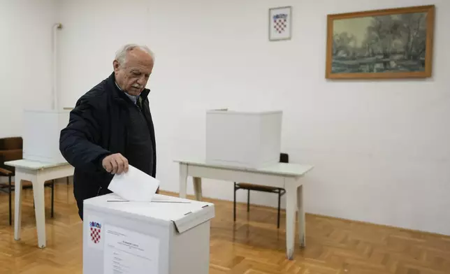 A man casts his ballot during a presidential election at a polling station in Zagreb, Croatia, Sunday, Dec. 29, 2024. (AP Photo/Darko Bandic)