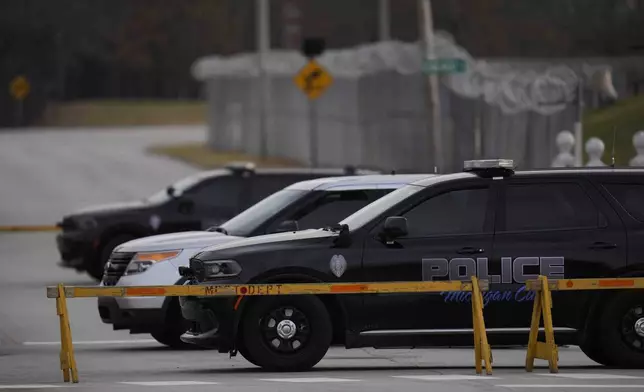 Police cars are parked outside of Indiana State Prison where, barring last-minute court action or intervention by Gov. Eric Holcomb, Joseph Corcoran, 49, convicted in the 1997 killings of his brother and three other people, is scheduled to be put to death by lethal injection before sunrise Tuesday, Dec. 17, 2024, in Michigan City, Ind. (AP Photo/Erin Hooley)