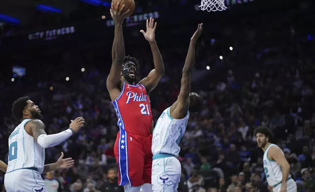 Philadelphia 76ers' Joel Embiid, left, goes up for a shot against Charlotte Hornets' Moussa Diabate during the second half of an NBA basketball game, Friday, Dec. 20, 2024, in Philadelphia. (AP Photo/Matt Slocum)