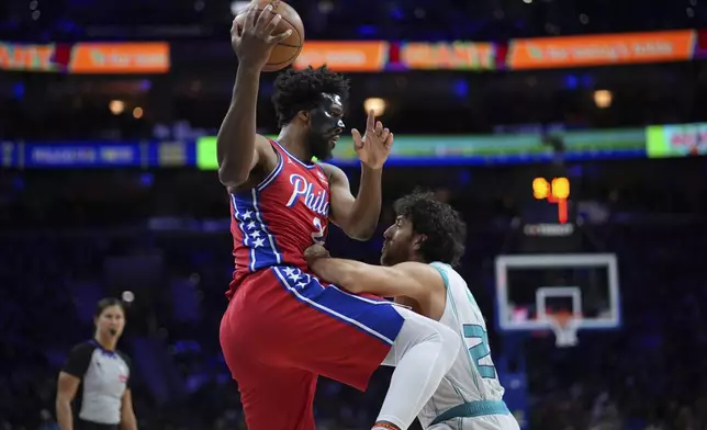 Philadelphia 76ers' Joel Embiid left, tries to go up for a shot against Charlotte Hornets' Vasilije Micic during the second half of an NBA basketball game, Friday, Dec. 20, 2024, in Philadelphia. (AP Photo/Matt Slocum)