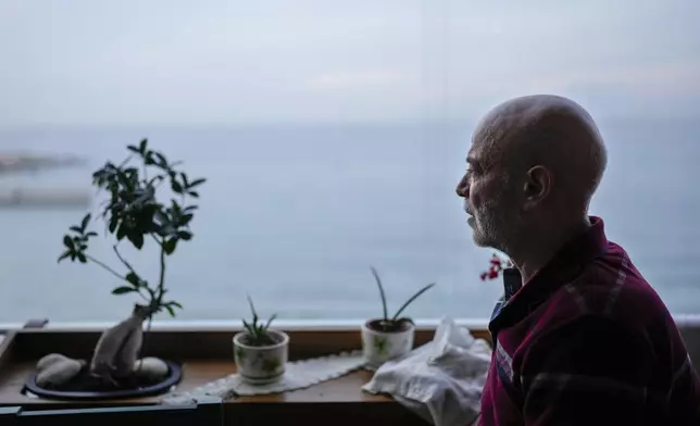 Suheil Hamwi, who spent 32 years in a prison in Syria and returned to Lebanon after the government of Bashar Assad was toppled, sits on the balcony of his home watching the sea in Chekka, Lebanon, Tuesday, Dec. 10, 2024. (AP Photo/Hassan Ammar)