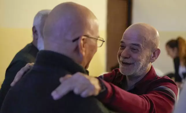 A neighbor welcomes Suheil Hamwi, right, who spent 32 years in prison in Syria, at Hamwi's home in Chekka, Lebanon, Tuesday, Dec. 10, 2024. (AP Photo/Hassan Ammar)