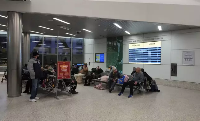 Commuters wait inside the George Washington Bridge Bus Station in New York, Friday, Dec. 6, 2024, where the gunman fleeing Wednesday's shooting of UnitedHealthcare CEO Brian Thompson took a taxi to, according to surveillance video. (AP Photo/Richard Drew)