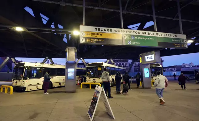 Commuters wait for buses at the George Washington Bridge Bus Station in New York, Friday, Dec. 6, 2024, where the gunman fleeing Wednesday's shooting of UnitedHealthcare CEO Brian Thompson took a taxi to, according to surveillance video. (AP Photo/Richard Drew)